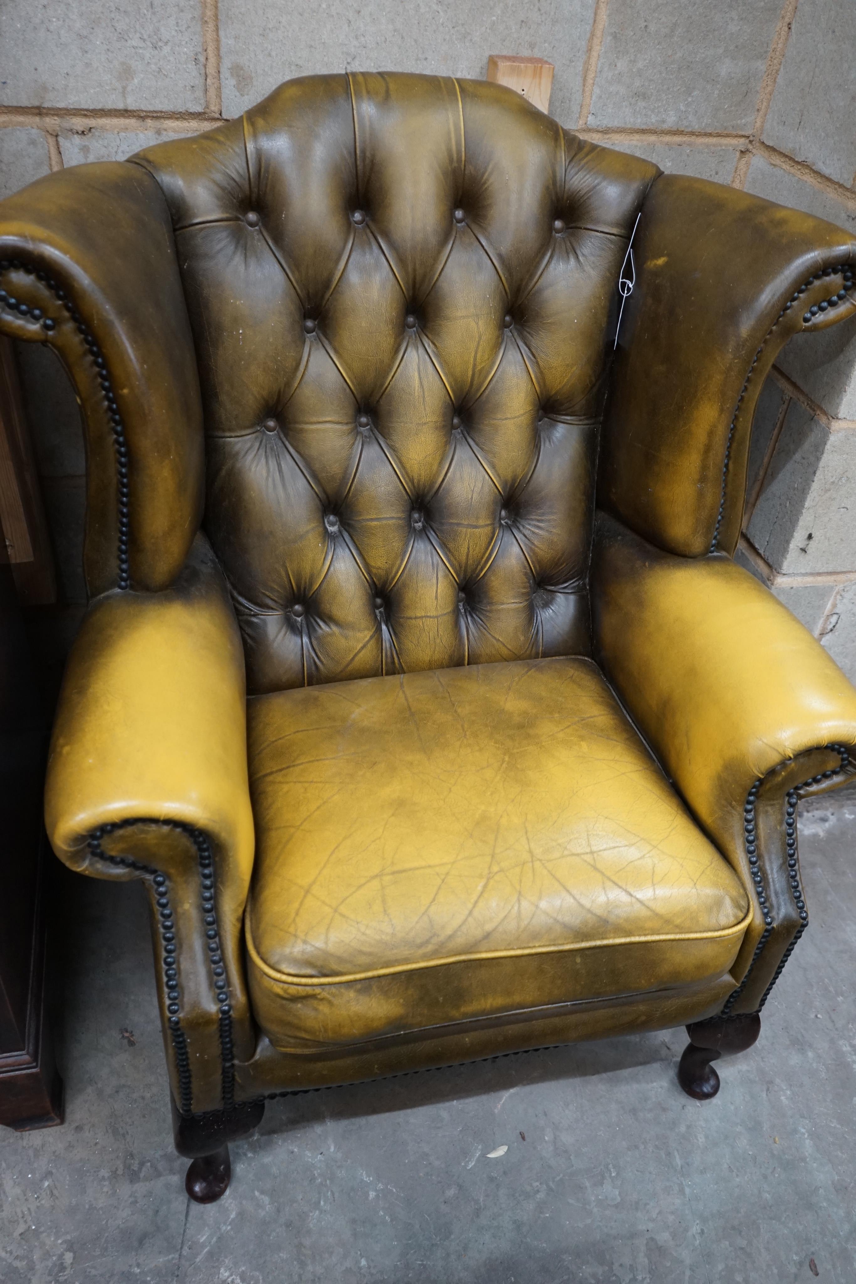 A Victorian style green leather wing armchair, width 82cm depth 76cm height 100cm